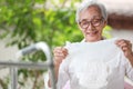 Happy smiling asian senior woman holding disposable diaper for adult,looking at nappy pamper with satisfaction,old elderly patient Royalty Free Stock Photo