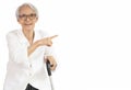 Happy smiling asian senior woman wearing eyeglasses holding walking cane,pointing finger at the empty copy space aside isolated on Royalty Free Stock Photo