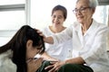 Happy smiling asian senior woman is stroking her child girl head, welcoming her family,loving daughter with her mother comes to