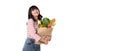 Happy smiling Asian woman holding paper shopping bag full of vegetables isolated on banner background with copy space Royalty Free Stock Photo