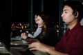 Happy smiling Asian woman work at call center service consultant working with teammate colleague overnight, night shift customer Royalty Free Stock Photo