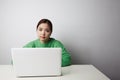 Happy smiling asian woman working on laptop computer. White background. Space for text. Royalty Free Stock Photo