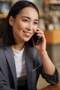 Happy Asian young adult business woman talking on cell phone making call. Royalty Free Stock Photo