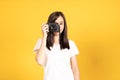 Happy smiling asian young girl photographer and looking viewfinder on retro digital mirrorless photo camera Royalty Free Stock Photo