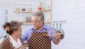 Happy & smiling attractive elderly cute Asian couple in love enjoying cooking healthy salad in kitchen at home together. Happiness Royalty Free Stock Photo