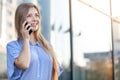 Happy smiling attractive woman talking on mobile phone near the office building Royalty Free Stock Photo
