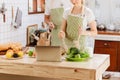 Happy & smiling attractive young cute caucasian couple in love enjoying cooking healthy salad in kitchen at home together. Royalty Free Stock Photo