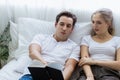 Happy & smiling attractive young cute caucasian couple in love enjoying reading book toghether in bedroom at home. Happiness Royalty Free Stock Photo