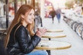 Happy smiling attractive young woman with cup of coffee in street cafe Royalty Free Stock Photo