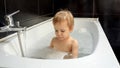 Happy smiling baby boy playing and splashing in the bath while getting clean and washing up Royalty Free Stock Photo