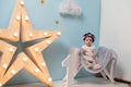 Happy smiling sweet baby girl sitting on armchair with shining light star, Birthday girl, One year old