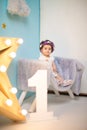 Happy smiling sweet baby girl sitting on armchair with shining light star, Birthday girl, One year old Royalty Free Stock Photo