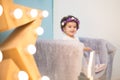 Happy smiling sweet baby girl sitting on armchair with shining light star, Birthday girl,  One year old Royalty Free Stock Photo