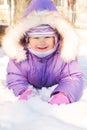 Happy smiling baby lying in the snow Royalty Free Stock Photo