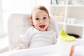 Happy smiling baby sitting in highchair at home Royalty Free Stock Photo