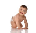 Happy smiling baby toddler in diaper is crawling on all fours looking up and aside Royalty Free Stock Photo