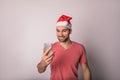 Happy smiling bearded handsome man in Canta Clause hat having online video call via smartphone Royalty Free Stock Photo