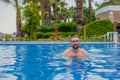Happy smiling bearded man in the swimming pool on sunny day Royalty Free Stock Photo