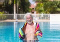 Happy smiling bearded senior people with white hair standing in the swimming pool with a colorful towel in the hands - active Royalty Free Stock Photo