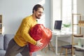 Happy young man holding heart-shaped Valentine balloon he prepared for his girlfriend Royalty Free Stock Photo
