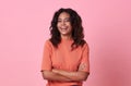 Happy smiling beautiful african woman looking at camera wearing casual orange t-shirt on pink background