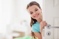 Happy smiling beautiful girl behind door at home Royalty Free Stock Photo