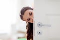 Happy smiling beautiful girl behind door at home Royalty Free Stock Photo