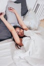 Happy smiling beautiful long hair asian girl young woman lying down in bed, cozy morning Royalty Free Stock Photo