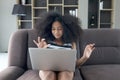 Happy smiling beautiful teenage girl with curly hair using laptop computer watching videos or movie and eating snacks while Royalty Free Stock Photo