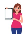 Happy smiling beautiful young woman holding / showing a blank clipboard and pointing with pen. Royalty Free Stock Photo