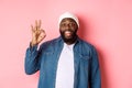 Happy smiling Black guy showing okay sign, approve and praise good offer, standing over pink background Royalty Free Stock Photo