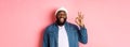 Happy smiling Black guy showing okay sign, approve and praise good offer, standing over pink background Royalty Free Stock Photo