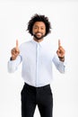 Happy smiling black man in formal wear looking at camera, pointing up with the index fingers at copy space in which to Royalty Free Stock Photo