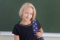 Happy schoolgirl preteen with a backpack in a classroom near a chalkboard. Back to school.