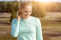 Happy smiling blonde sporty woman enjoys sun after workout outdoors in nature on a sunny day Royalty Free Stock Photo