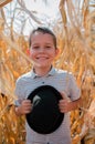 Happy smiling boy. Cute young 10 year old boy with black hat in his hands. Child in hte corn field - harvest season