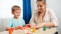 Happy smiling boy with dirty hands in colorful paint looking at mother drawing picture with fingers and gouache. family Royalty Free Stock Photo