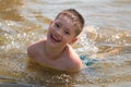 Happy smiling boy emerges from the water