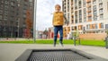 Happy smiling boy enjoys jumping and playing on playground with trampoline. Active child, sports and development, kids playing Royalty Free Stock Photo