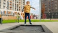 Happy smiling boy laughs and enjoys jumping on the trampoline. Active child, sports and development, kids playing outdoors Royalty Free Stock Photo