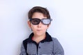 Happy smiling boy looking through sunglasses, studio shoot on wh Royalty Free Stock Photo