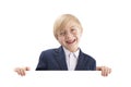 Happy smiling boy posing with empty white paper board and laughs. Cute blond boy peeking out from behind white board Royalty Free Stock Photo