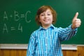 Happy smiling boy show thub up on blackboard background . Educational and school concept Royalty Free Stock Photo