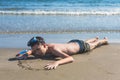 Happy and smiling boy in the snorkeling mask and tube on the sand on the beach.