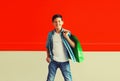 Happy smiling boy teenager with shopping bag in the city on red background Royalty Free Stock Photo