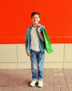 Happy smiling boy teenager with shopping bag in the city on red background Royalty Free Stock Photo