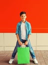 Happy smiling boy teenager with shopping bag in the city on red background Royalty Free Stock Photo