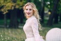 Happy, smiling bride with curly blonde hair. Portrait of beautiful girl on green nature background. Close-up Royalty Free Stock Photo