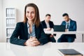 Happy smiling business woman portrait sitting in office with her business team on background Royalty Free Stock Photo