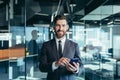 Happy and smiling businessman having fun using phone, typing messages on phone, smiling and looking at camera, close-up portrait Royalty Free Stock Photo